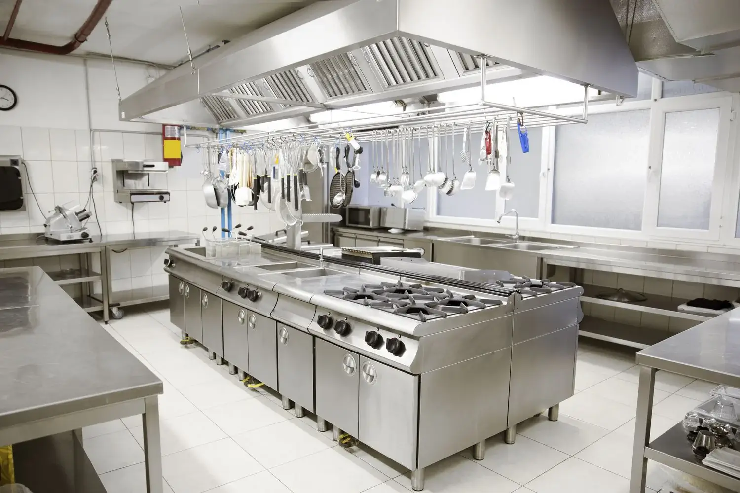 Modern commercial kitchen interior with stainless steel appliances and professional equipment